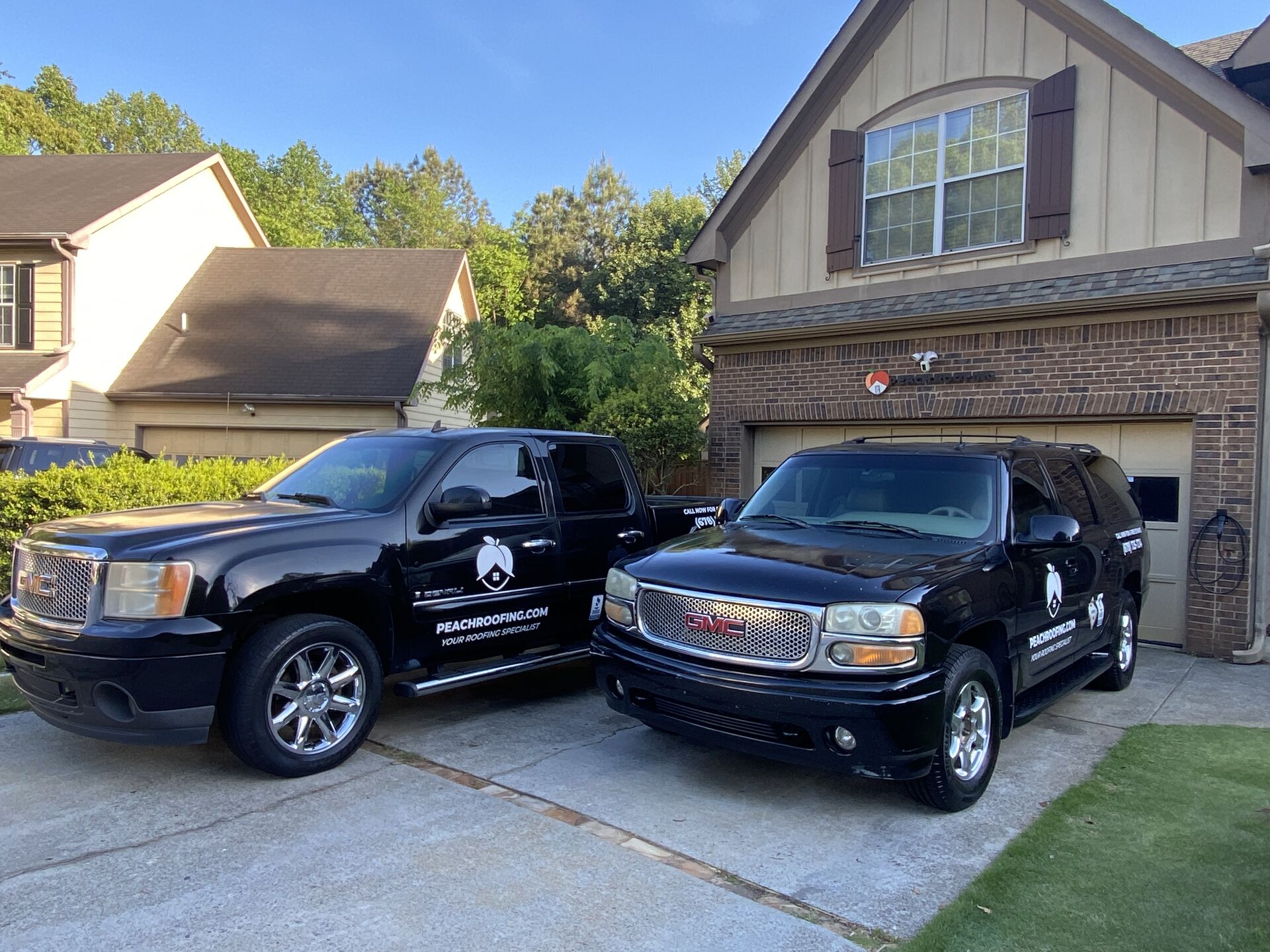 Two Peach Roofing trucks parked at our Lawrenceville workplace.
